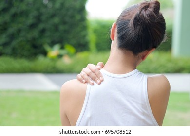 Women have neck pain, shoulder pain, at the park health concept. - Powered by Shutterstock