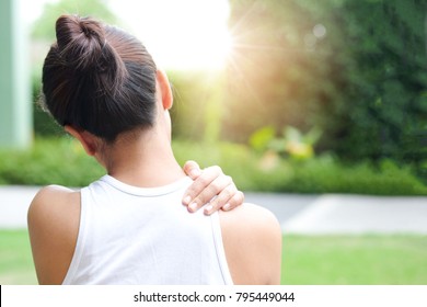 Women have neck pain, shoulder pain, at the park health concept.