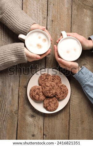 Women having coffee break at wooden table, top view