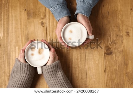Women having coffee break at wooden table, top view