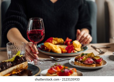 Women Having Dinner At The Restaurant, Holding Glass Of Red Wine In Hands.