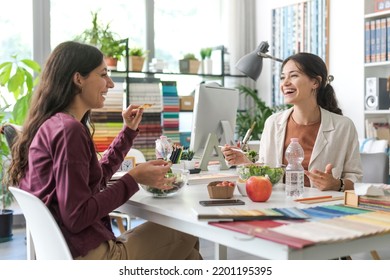 Women having a lunch break together in the office, they are eating salad and talking to each other - Shutterstock ID 2201195395
