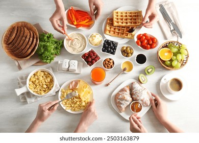 Women having tasty breakfast at light wooden table, top view - Powered by Shutterstock