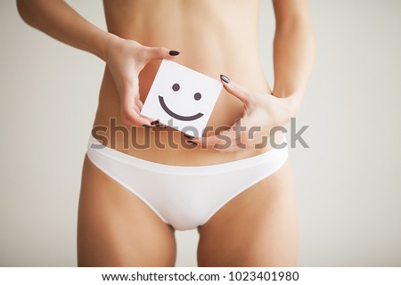 Women Health. Closeup Of Healthy Female With Beautiful Fit Slim Body In White Panties Holding White Card With Happy Smiley Face In Hands. Stomach Health And Good Digestion Concepts. High Resolution