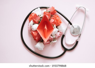 women Health. red paper boat on flower buds. abstract symbolic image of the female reproductive system