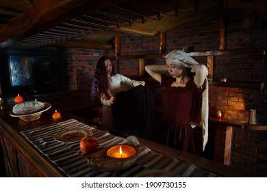 Women In Historical Costumes. Two Maids Are Preparing Food In The Tavern. A Scene From Medieval Life. Historical Reconstruction Of A Restaurant Lunch. Girls In Vintage Dresses. Renaissance Painting