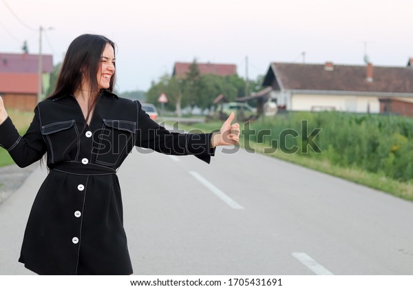 Women hitchhiking while traveling in Croatia. Summer
time. Happy women 