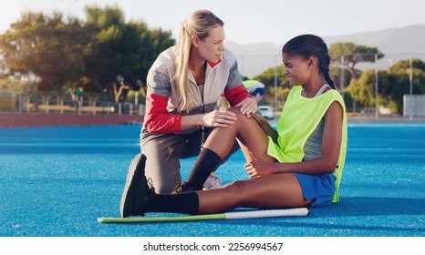 Women, hockey coach and knee injury girl on field together with support, solidarity or care at sport training. Sports woman, coaching or help at workout for joint pain at outdoor exercise with mentor - Powered by Shutterstock