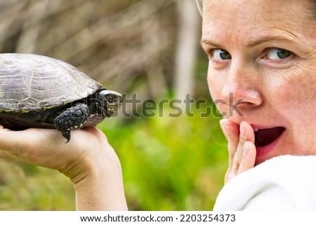 Women hold European turtle, close up portrait. Happy women at the turtle sanctuary hatchery.