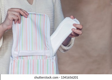 Women Hold A Menstrual Pad. Young Woman Taking Out A Sanitary Pad From Her Bag. White Menstrual Pad. Sanitary Woman Hygiene.