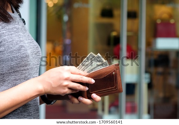 Women hold money in wallets,\
backgrounds, bags and fashion items.Concept business ideas and\
shopping