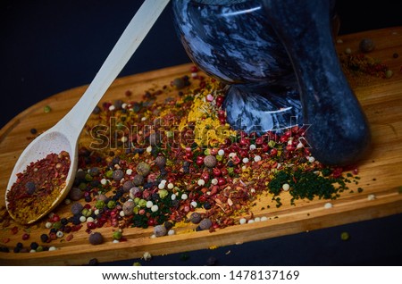 The women hold pestle with mortar and spice paste . Red paste ingredients for red curry on rustic wooden background. Spice ingredients chili ,pepper, garlic,galanga, lemongrass and Kaffir lime leaves.