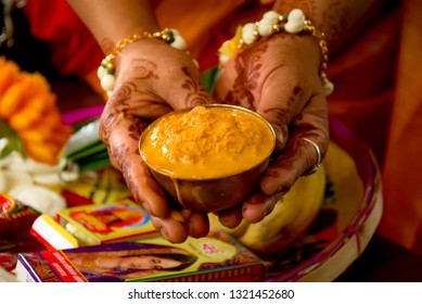 A women holding a bowl of turmeric for her wedding ceremony. Its a rituals of traditional Hindu wedding which is known as Haldi ceremony.