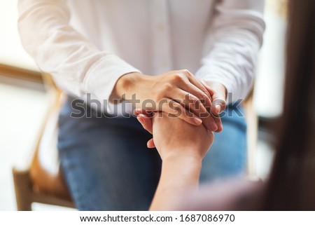 Women holding each other hands for comfort and sympathy Stock photo © 