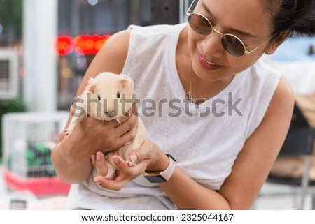 Women holding guinea pig  at outdorrs garden