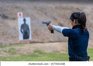 Women holding gun aiming pistol in shooting range. Concept sport practice training