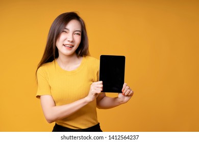 Women Holding Ipad, Smiling, Cute, Bright Wearing A Yellow Dress On A Yellow Background