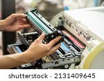 Women holding Laser toner cartridge ,replacing toner in laser printer at office. Repairs and Maintenance printers concept ,selective focus