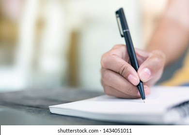 Women holding a pen writing a notebook. Recording concept