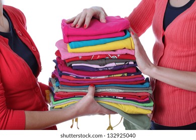 Women Holding Pile Of Ironed And Colorful Clothes