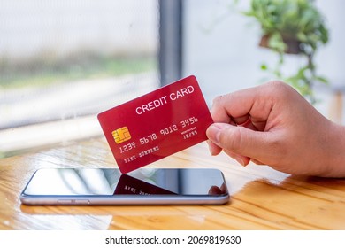 Women holding a red credit card to shop online, credit cards can accumulate points to use points for online shopping, credit cards to use installments. - Shutterstock ID 2069819630