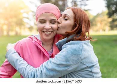 women hugging with closed eyes while kissing the fighter against cancer - concept fight against breast cancer -
