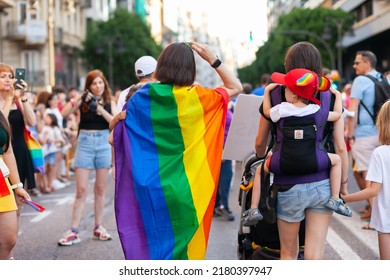 Women With Kids And Rainbow Flag At Pride. Real People At Pride Parade Event, Supporting The Rights Of LGBTQIA Community And Celebrating Freedom With Rainbow Flags - VALENCIA, SPAIN: 25 JUNE 2022