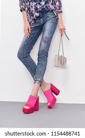 Women Leg In Sequin Jeans With Red Shoes With Handbag Posing Gray Background
