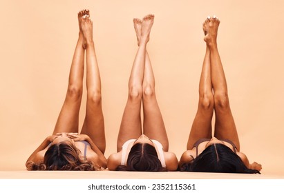 Women, legs and beauty with diversity, skincare and epilation for hair removal and wellness. Studio, yellow background and waxing with female model group feet and skin glow treatment with pedicure