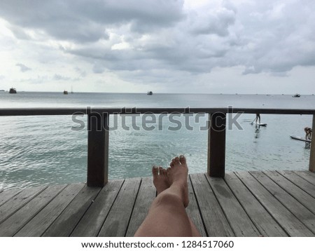 Women legs on wood terrace sea view