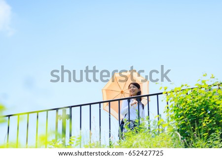 Woman with sunglasses raising her arms over nature background