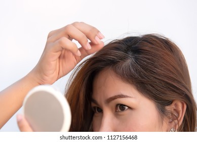 women are looking at the mirror to see the gray hair and hair loss problem