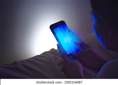 Women Looking At Mobile Phones In Low Light And The Blue Light From The Phone Has Bad Effects On The Eyes.