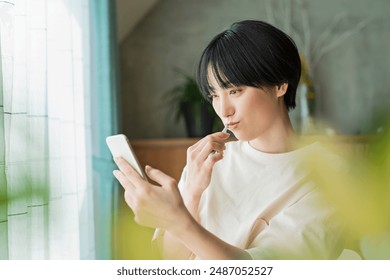 Women looking at mobile phones while brushing their teeth - Powered by Shutterstock