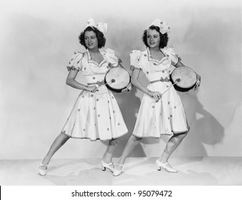 Women in matching outfits playing drums