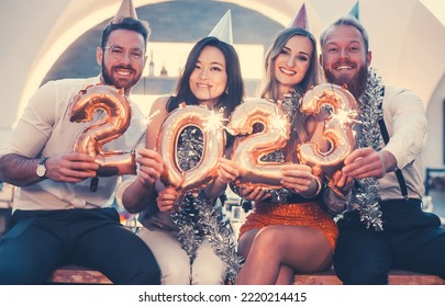 Women and men celebrating the new year 2023 - Shutterstock ID 2220214415
