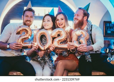 Women and men celebrating the new year 2023 - Shutterstock ID 2231339769