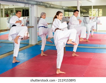 Women and men of different ages doing kata during group karate training.