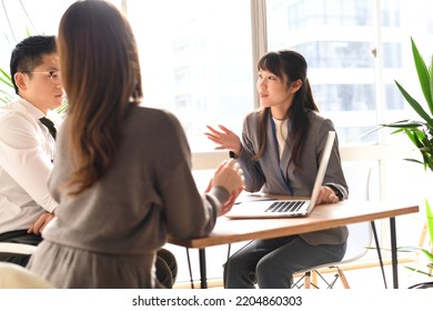 Women and men having a meeting indoors using a personal computer - Shutterstock ID 2204860303