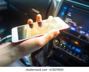women with mobile phones in their hands riding in car