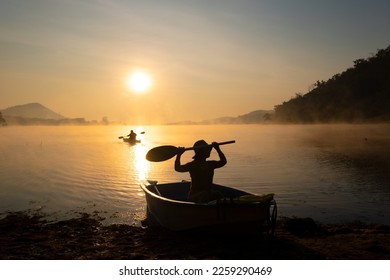 Women  mooring a boat to the shore at the reservoir during the sunrise - Powered by Shutterstock