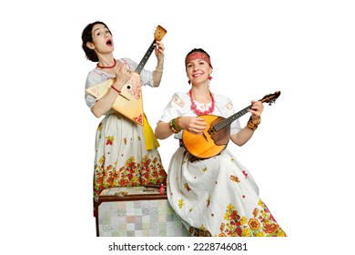 Women musicians in Russian folk dresses with musical instruments on a isolated white background. Happy artists from Russia in white national clothes with stringed musical instruments - Powered by Shutterstock