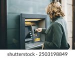 Women on ATM machine withdrawing cash