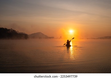 Women on kayak rows in the reservoir during the sunrise, Harirak forest park Huai Nam Man reservoir Loei Thailand - Powered by Shutterstock