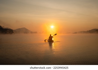 Women on kayak rows in the reservoir during the sunrise, Harirak forest park Huai Nam Man reservoir Loei Thailand - Powered by Shutterstock