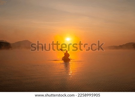 Women on kayak rows in the reservoir during the sunrise, Harirak forest park Huai Nam Man reservoir Loei Thailand