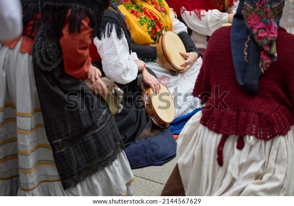 Women in period costumes\
playing tambourines at a popular festival in the city of Vigo,\
Galicia, Spain.