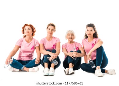 women in pink t-shirts with breast cancer awareness ribbons holding bottles of water and looking at camera while sitting isolated on white - Powered by Shutterstock