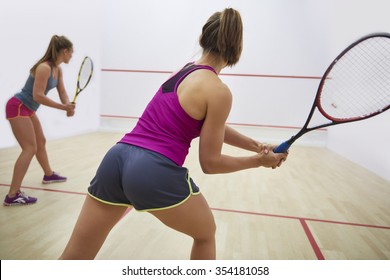 Women playing racket sport indoors