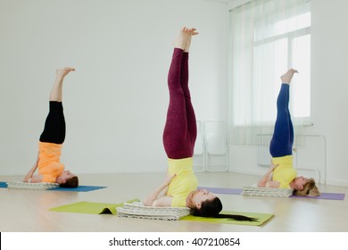 women practicing the Sarvangasana (Shoulder Stand) - Powered by Shutterstock